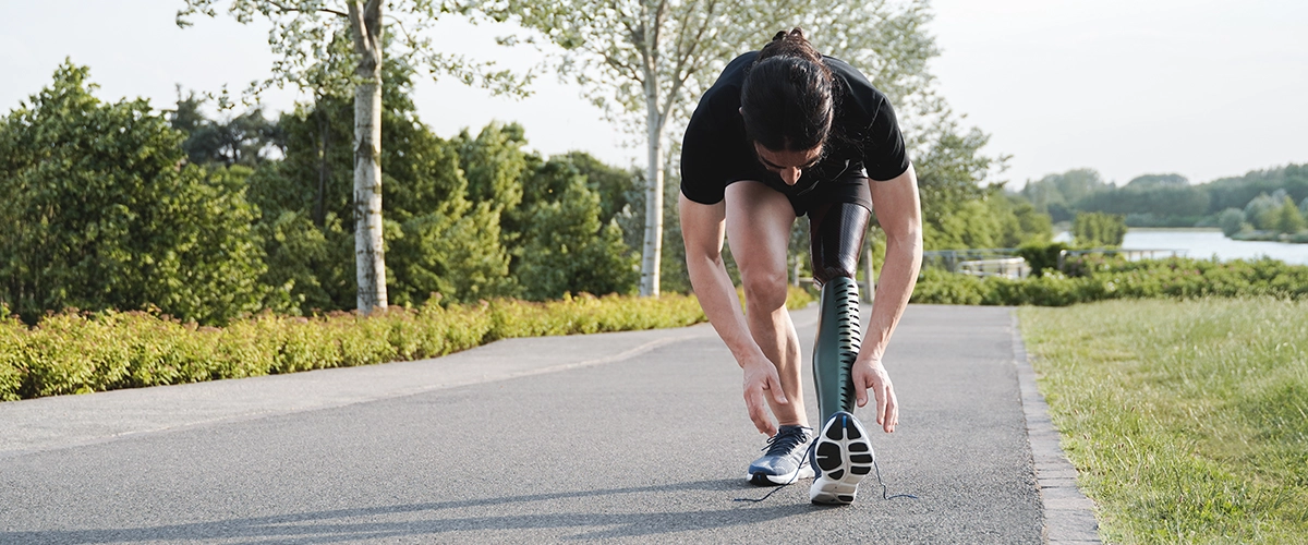 person stretching with a prosthetic let for a run